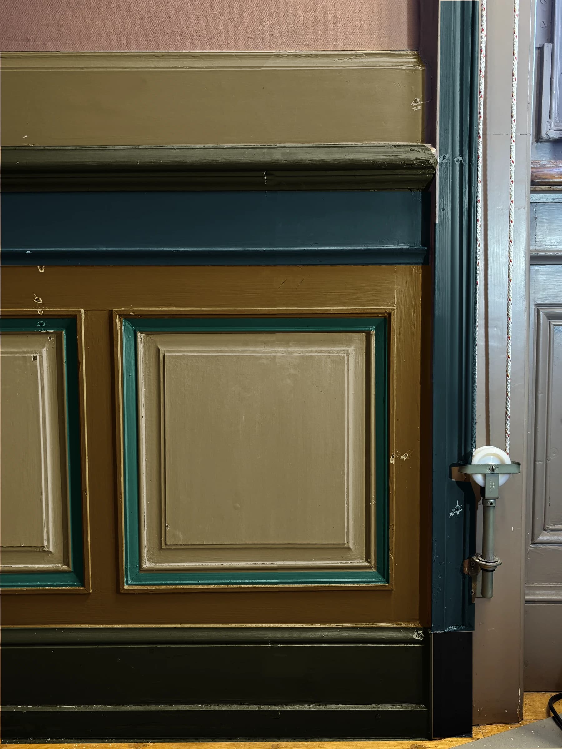 Interprétation chromatique numérique des mêmes boiseries, avec des zones kaki, bleu profond, vert foncé et émeraude suivant la cartographie des sondages.